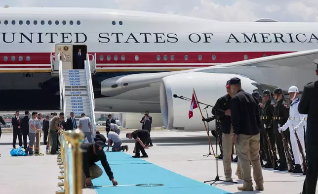 Staff lay a carpet on the tarmac before President Donald Trump exits Air Force One upon arriving for the NATO summit in Ankara, Turkey, Tuesday, July 7, 2026. (AP Photo/Alex Brandon)
