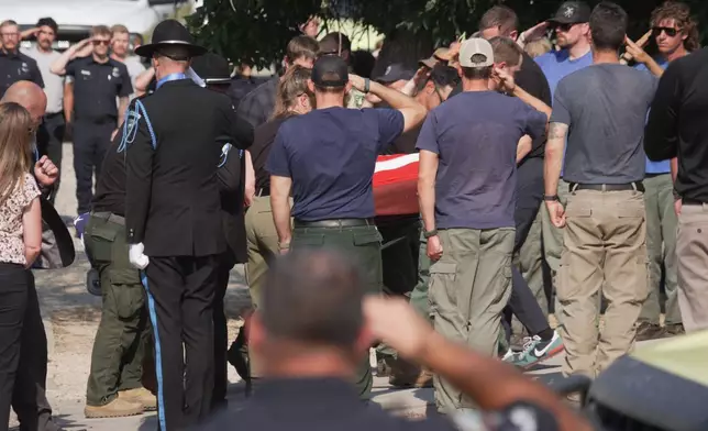 The body of a firefighter who died battling wildfires near the Colorado-Utah border is carried during a procession in Grand Junction, Colo., Monday, June 29, 2026. (AP Photo/Ty ONeil)