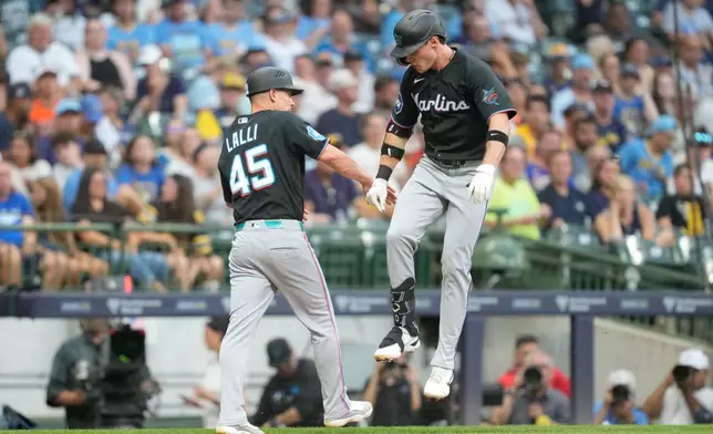 Miami Marlins' Griffin Conine, right, celebrates with third base coach Blake Lalli (45) after hitting a home run during the fifth inning of a baseball game against the Milwaukee Brewers, Friday, July 17, 2026, in Milwaukee. (AP Photo/Kayla Wolf)