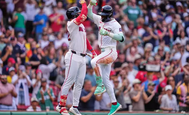 Boston Red Sox's Ceddanne Rafaela, right, is congratulated by Wilyer Abreu after hitting a solo home run in the fourth inning during the first baseball game of a doubleheader against the Baltimore Orioles, Wednesday, July 22, 2026, in Boston. (AP Photo/Charles Krupa)