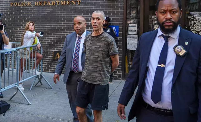 Raul Morales, a 51-year-old man who is accused of stabbing two people on the Upper West Side in Manhattan on Thursday afternoon is escorted out of the NYPD 20th Precinct by police officers in New York, Friday, July 24, 2026. (AP Photo/Ryan Murphy)