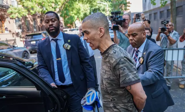 Raul Morales, a 51-year-old man who is accused of stabbing two people on the Upper West Side in Manhattan on Thursday afternoon is escorted out of the NYPD 20th Precinct by police officers in New York, Friday, July 24, 2026. (AP Photo/Ryan Murphy)