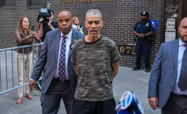 Raul Morales, a 51-year-old man who is accused of stabbing two people on the Upper West Side in Manhattan on Thursday afternoon is escorted out of the NYPD 20th Precinct by police officers in New York, Friday, July 24, 2026. (AP Photo/Ryan Murphy)