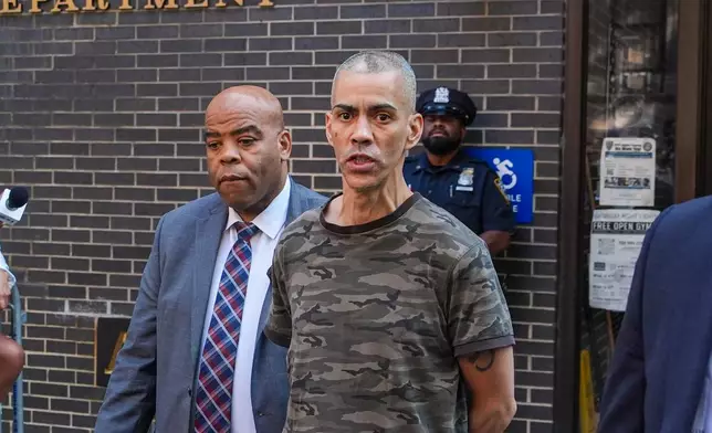 Raul Morales, a 51-year-old man who is accused of stabbing two people on the Upper West Side in Manhattan on Thursday afternoon is escorted out of the NYPD 20th Precinct by police officers in New York, Friday, July 24, 2026. (AP Photo/Ryan Murphy)