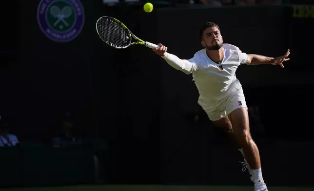 Dino Prizmic of Croatia returns the ball to Felix Auger-Aliassime of Canada in their second round men's singles match at the Wimbledon Tennis Championships in London, Wednesday, July 1, 2026. (AP Photo/Kin Cheung)