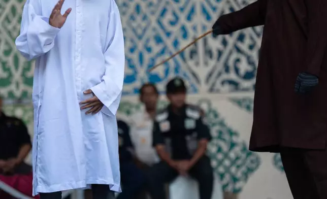 A man is publicly caned after he was convicted of violating Islamic law by kissing during a TikTok livestream, in Banda Aceh, Indonesia, Thursday, July 2, 2026. (AP Photo/Reza Saifullah)