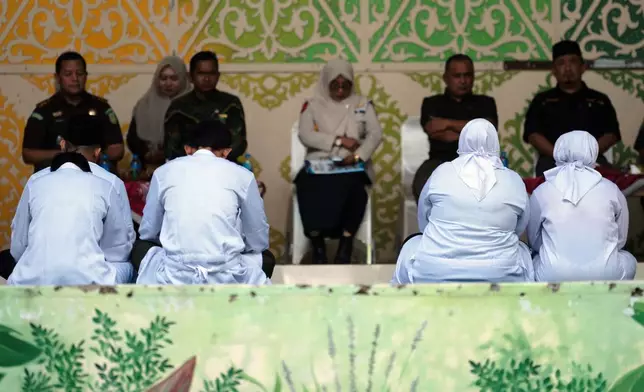 People convicted of violating Islamic law, among them are an unmarried couple who were found gulty of kissing during a TikTok livestream, wait for their turn to be publicly caned in Banda Aceh, Indonesia, Thursday, July 2, 2026. (AP Photo/Reza Saifullah)