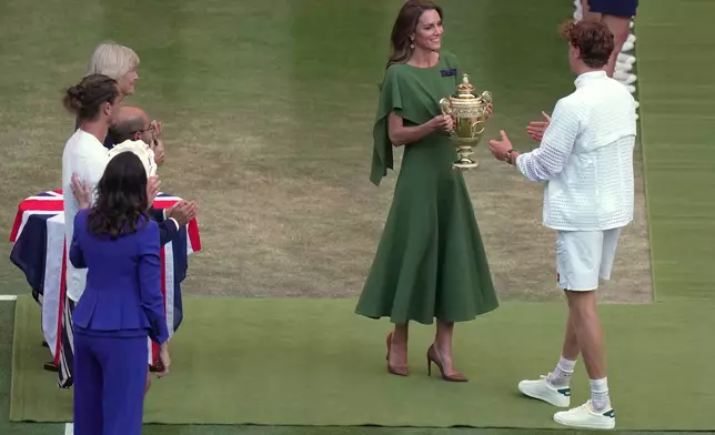 Britain's Princess Kate presents the champion trophy to Jannik Sinner of Italy after winning against Alexander Zverev of Germany in the men's singles final at Wimbledon Tennis Championships in London, Sunday, July 12, 2026. (AP Photo/Brian Inganga)
