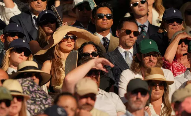 Singer Jennifer Lopez, centre, and Actor Tom Hiddleston watch the men's singles final at Wimbledon Tennis Championships in London, Sunday, July 12, 2026. (AP Photo/Kin Cheung)