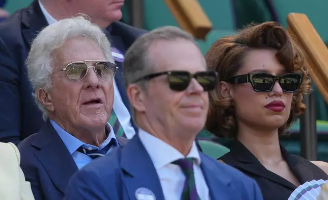 Actor Dustin Hoffman, left and Singer- songwriter Raye watches play in the women's doubles final final at Wimbledon Tennis Championships in London, Sunday, July 12, 2026. (AP Photo/Kin Cheung)
