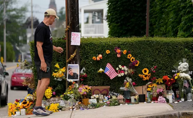 A man pauses to view a makeshift memorial to the victim of a shooting involving U.S. Immigration and Customs Enforcement, Tuesday, July 14, 2026 in Biddeford, Maine. (AP Photo/Robert F. Bukaty)