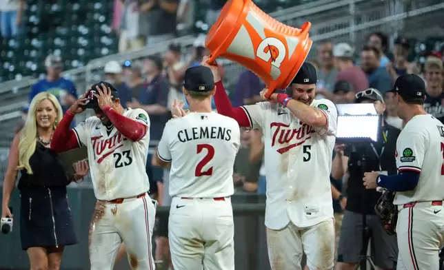 Minnesota Twins' Ryan Kreidler (5) takes a bucket of Gatorade off his head after he and Royce Lewis, second from left, were doused after Lewis' hit an RBI triple walk-off scoring Victor Caratini and Brooks Lee in the ninth inning of a baseball game against the Kansas City Royals, Tuesday, July 28, 2026, in Minneapolis. (AP Photo/Joseph Scheller)