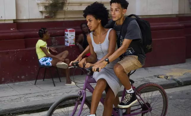 A couple rides a bicycle during a blackout in Havana, Cuba, Tuesday, July 14, 2026. (AP Photo/Ramon Espinosa)