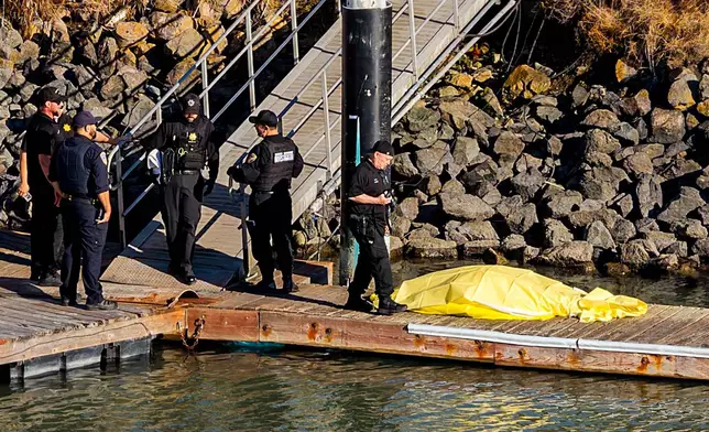 First responders stand near a body after a boat accident near Alcatraz Island off San Francisco, Tuesday, July 14, 2026. (AP Photo/Noah Berger)