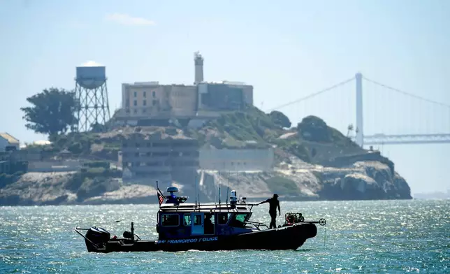 A police boat passes Alcatraz Island as search and rescue operations continue for victims of a Tuesday boat sinking on Wednesday, July 15, 2026, in San Francisco. (AP Photo/Noah Berger)