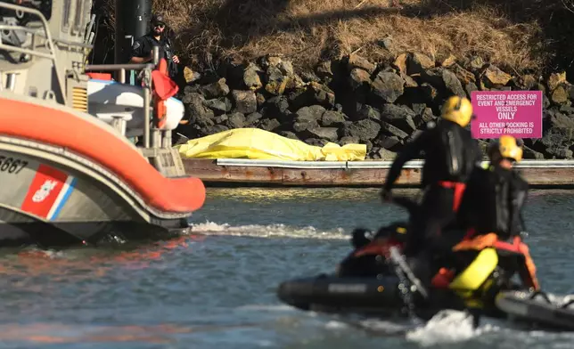A body is covered with a tarp on a dock near the site of boat accident on Tuesday, July 14, 2026, in San Francisco. (AP Photo/Noah Berger)