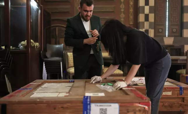 Museum employees prepare to unpack crates containing antiquities returned from France at the National Museum in Damascus, Syria, Wednesday, July 8, 2026. (AP Photo/Ghaith Alsayed)