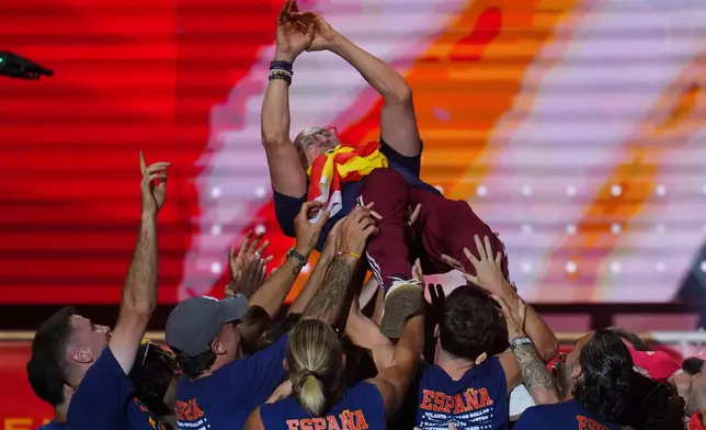 Spain's head football coach, Luis de la Fuente, is carried aloft by his players during celebrations at Cibeles Square in Madrid on Monday, July 20, 2026, after Spain defeated Argentina in the World Cup final in East Rutherford, N.J., near New York. (AP Photo/Manu Fernandez)