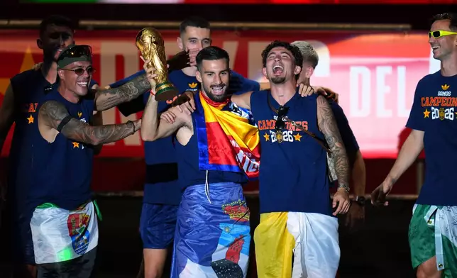 Spain's Alex Baena holds the trophy during celebrations with his national team teammates at Cibeles Square in Madrid on Monday, July 20, 2026, after Spain defeated Argentina in the World Cup final in East Rutherford, N.J., near New York. (AP Photo/Manu Fernandez)