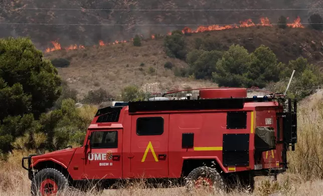 A Military Emergency Unit vehicle operates as a wildfire rages in Alfajir, near Almeria in southeastern Spain, Friday, July 10, 2026. (AP Photo/Gregorio Marrero)