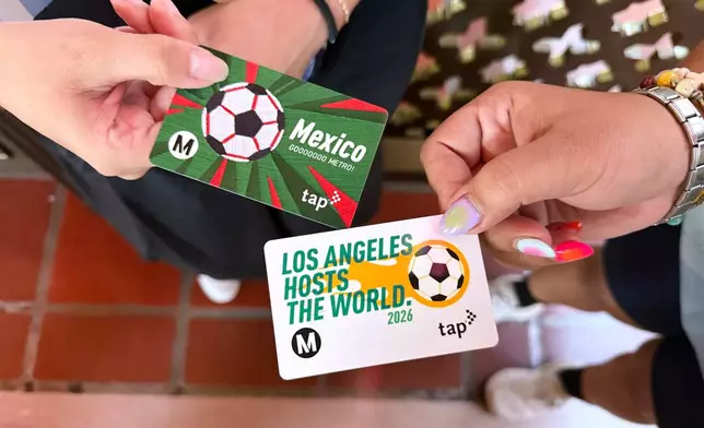 Michelle Valladares, left, and Yasmin Cortez show their FIFA World Cup themed Metro tap cards before attending a watch party on Friday, June 26, 2026, in Los Angeles. (AP Photo/Jaimie Ding)