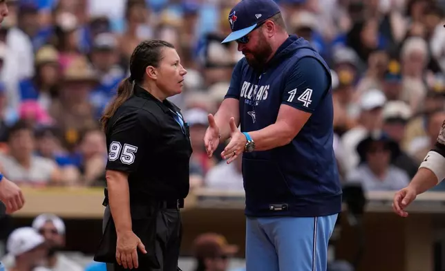 Home plate umpire Jen Pawol (95) speaks with Toronto Blue Jays manager John Schneider during the second inning of a baseball game against the San Diego Padres Sunday, July 12, 2026, in San Diego. (AP Photo/Gregory Bull)