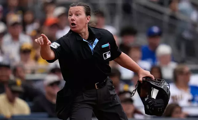 Home plate umpire Jen Pawol (95) gestures towards the San Diego Padres dugout after hitting coach Steven Souza Jr. was ejected during the second inning of a baseball game against the Toronto Blue Jays Sunday, July 12, 2026, in San Diego. (AP Photo/Gregory Bull)