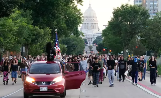 Protesters march after a Madison police officer shot and killed a man Wednesday, July 22, 2026, in Madison, Wis. (AP Photo/Kayla Wolf)