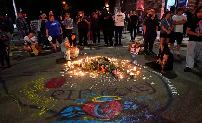 Attendees gather at a candlelight vigil where a Madison police officer shot and killed a man Wednesday, July 22, 2026, in Madison, Wis. (AP Photo/Kayla Wolf)