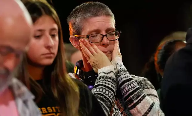 An attendee reacts at a candlelight vigil where a Madison police officer shot and killed a man Wednesday, July 22, 2026, in Madison, Wis. (AP Photo/Kayla Wolf)