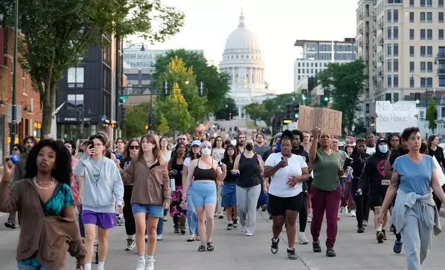 Protesters march after a Madison police officer shot and killed a man Wednesday, July 22, 2026, in Madison, Wis. (AP Photo/Kayla Wolf)