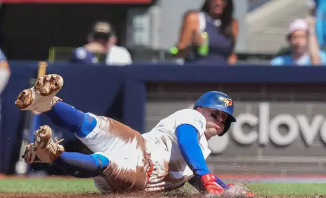 Toronto Blue Jays' Ernie Clement slides safely in to home to score against the Tampa Bay Rays during the first inning of a baseball game in Toronto, Thursday, July 23, 2026. (Nathan Denette/The Canadian Press via AP)