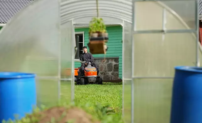 Estonia Monastery Rev. Paisios drives a riding lawn mower at the newly founded Kirikla Orthodox Monastery in Pihali village, Estonia, on July 4, 2026. (AP Photo/Sergei Grits)