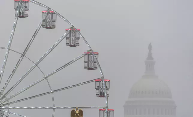 The U.S. Capitol is seen through fog behind the ferris wheel at the Great American State Fair on the National Mall, Sunday June 28, 2026, in Washington. (AP Photo/Jen Golbeck)