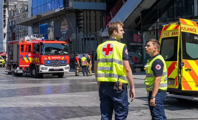 Emergency workers on site during a fire at a building complex in the center of Brussels, Tuesday, July 14, 2026. (AP Photo/Marius Burgelman)