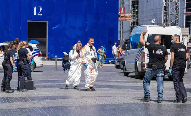 Emergency and forensic workers on site during a fire at a building complex in the center of Brussels, Tuesday, July 14, 2026. (AP Photo/Marius Burgelman)