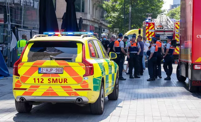 Emergency workers on site during a fire at a building complex in the center of Brussels, Tuesday, July 14, 2026. (AP Photo/Marius Burgelman)