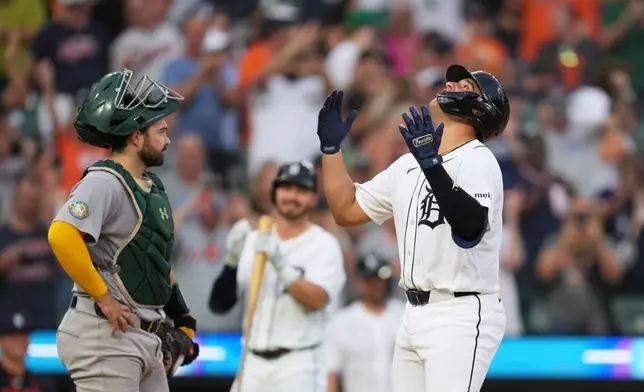 Detroit Tigers' Eduardo Valencia, right, reacts to hitting a home run as Athletics catcher Shea Langeliers, left, looks on during the seventh inning of a baseball game Thursday, July 9, 2026, in Detroit. (AP Photo/Paul Sancya)