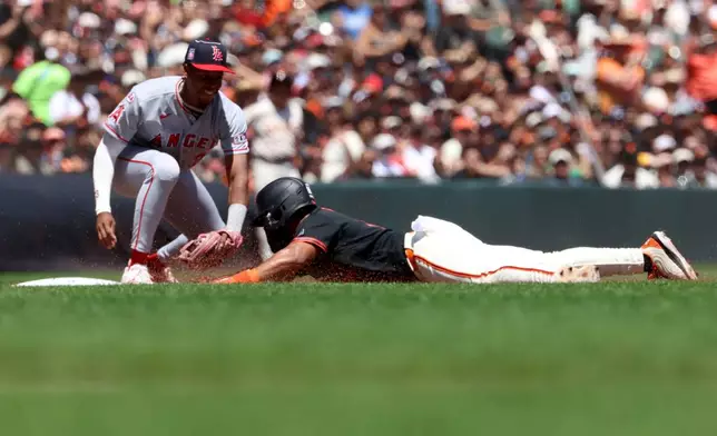 San Francisco Giants Heliot Ramos slides safely into third on a single by Rafael Devers in front of Los Angeles Angels third baseman Denzer Guzman during the third inning of a baseball game in San Francisco, Saturday, July 25, 2026. (AP Photo/Jed Jacobsohn)