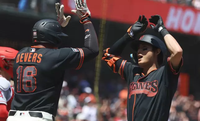 San Francisco Giants' Jung Hoo Lee, right, celebrates with Rafael Devers (16) after hitting a three-run home run against the Los Angeles Angels during the third inning of a baseball game in San Francisco, Saturday, July 25, 2026. (AP Photo/Jed Jacobsohn)
