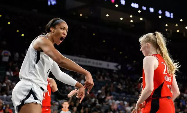 Las Vegas Aces center A'ja Wilson, left, reacts after making a basket and drawing a foul during the first half of an WNBA basketball game against the Portland Fire Tuesday, July 28, 2026, in Las Vegas. (Steve Marcus/Las Vegas Sun via AP)
