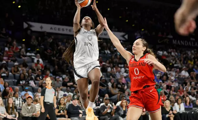 Las Vegas Aces guard Jackie Young (0) shoots a layup past Portland Fire guard Carla Leite (0) during the first half of an WNBA basketball game Tuesday, July 28, 2026, in Las Vegas. (Steve Marcus/Las Vegas Sun via AP)