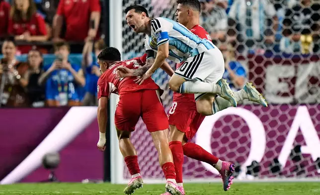 Argentina's Lionel Messi (10) falls while being fouled against by Switzerland's Zeki Amdouni, left, during the World Cup quarterfinal soccer match in Kansas City, Mo., Saturday, July 11, 2026. (AP Photo/Charlie Riedel)