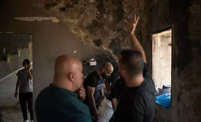 Palestinians gather to repair a damaged house following an attack by Israeli settlers the previous day in the village of Sarra, near the West Bank city of Nablus, Saturday, July 25, 2026. (AP Photo/Leo Correa)