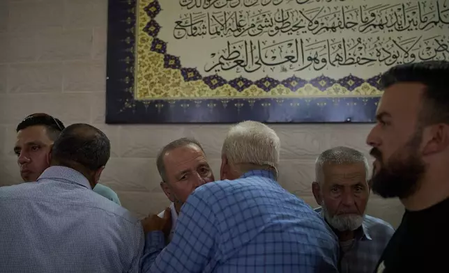 Hussein Ramadan, center left, father of two Palestinians killed by Israeli forces the previous day receives condolences from friends and neighbours in the village of Tell, near the West Bank city of Nablus, Saturday, July 25, 2026. (AP Photo/Leo Correa)