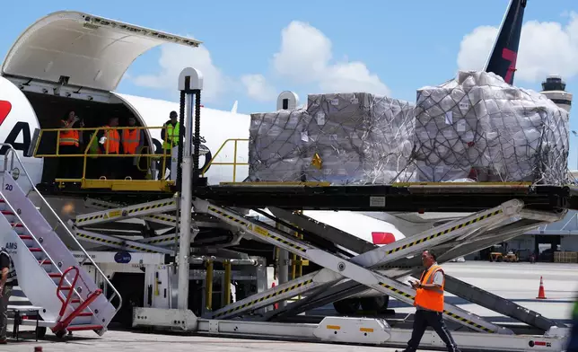 People load pallets containing food and hygiene kits for a humanitarian assistance flight to Cuba organized by the Trump administration as the U.S. continues to put pressure on the island's government, Tuesday, July 21, 2026, in Miami. (AP Photo/Lynne Sladky)