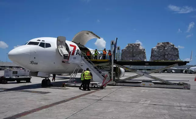 People load pallets containing food and hygiene kits for a humanitarian assistance flight to Cuba organized by the Trump administration as the U.S. continues to put pressure on the island's government, Tuesday, July 21, 2026, in Miami. (AP Photo/Lynne Sladky)