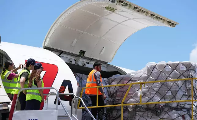 People load pallets containing food and hygiene kits for a humanitarian assistance flight to Cuba organized by the Trump administration as the U.S. continues to put pressure on the island's government, Tuesday, July 21, 2026, in Miami. (AP Photo/Lynne Sladky)