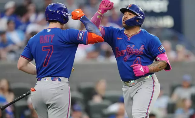 New York Mets' Francisco Alvarez (4) celebrates his solo home run against the Toronto Blue Jays with teammate Brett Baty (7) during the fifth inning of a baseball game in Toronto on Tuesday, June 30, 2026. (Nathan Denette/The Canadian Press via AP)