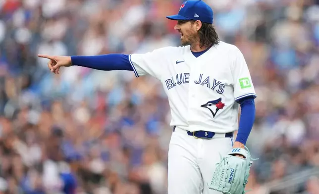 Toronto Blue Jays pitcher Kevin Gausman (34) gestures to a teammate against the New York Mets during the first inning of a baseball game in Toronto on Tuesday, June 30, 2026. (Nathan Denette/The Canadian Press via AP)